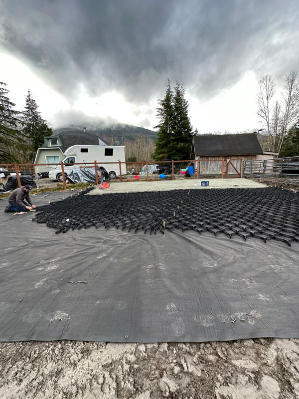 Gravel grid and non-woven geotextile underlayment being laid out for horse paddock.